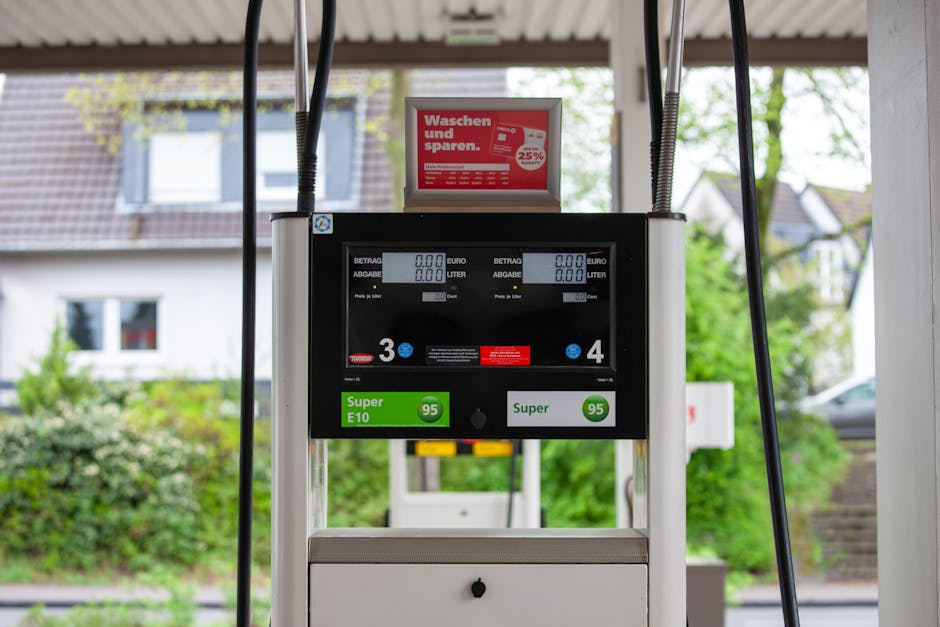 Close-up van een benzinepomp bij een tankstation in Bergisch Gladbach, Duitsland, met de omliggende huizen zichtbaar.