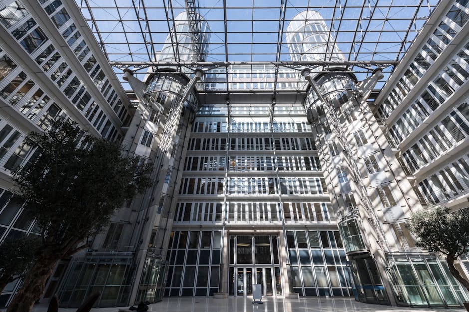 Groothoekbeeld van het atrium van een modern kantoorgebouw in Hamburg, met een staalkaart van de architectuur van glas en staal.
