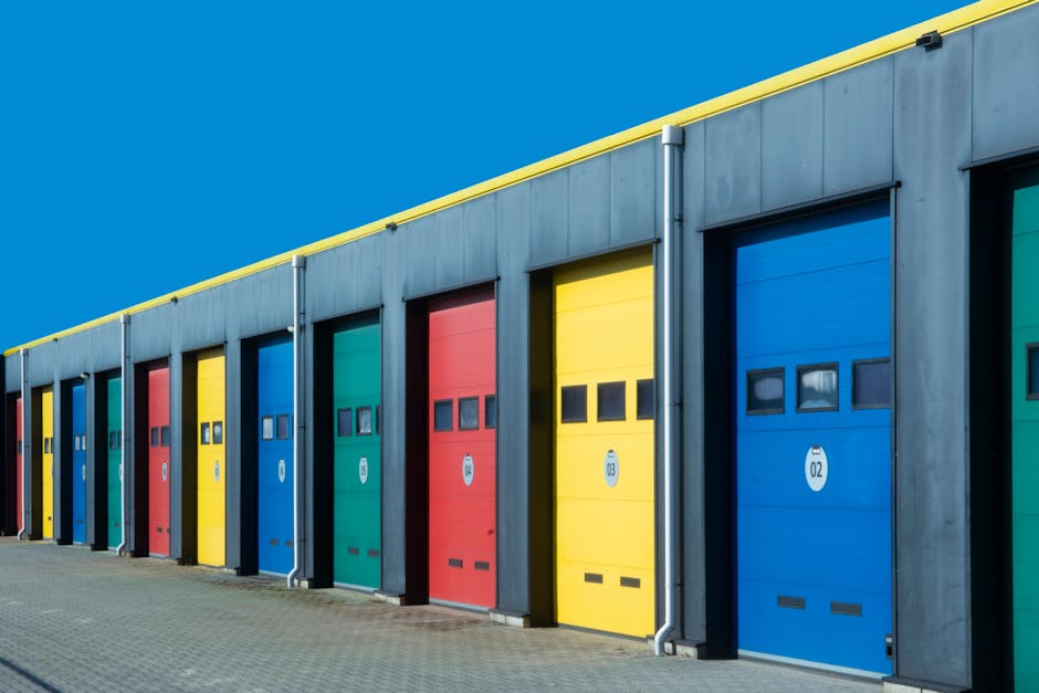 Levendige rij industriële garagedeuren in de kleuren blauw, rood, geel en groen, perfect voor commercieel gebruik.